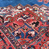 Heriz rug detailed blue, red, and cream vine motifs, angled close-up