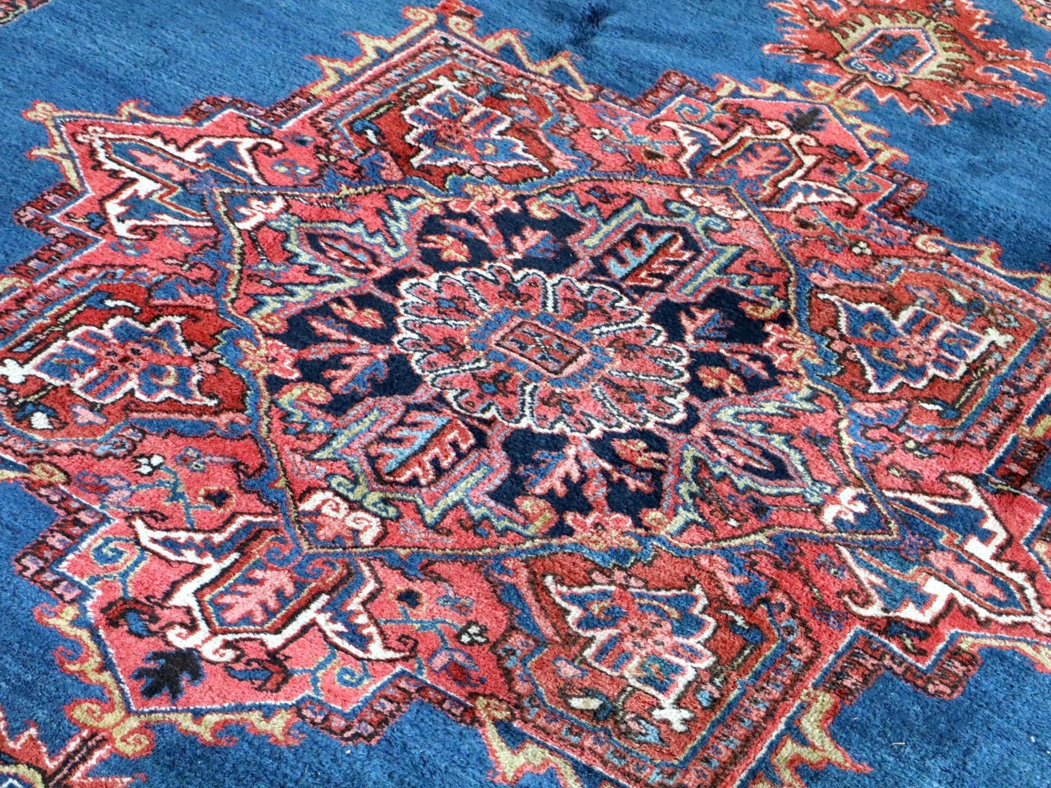 Persian Heriz rug fabric detail: blue ground with red and cream geometric motifs