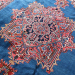 Persian Heriz rug center medallion on blue field with red ornamental surround