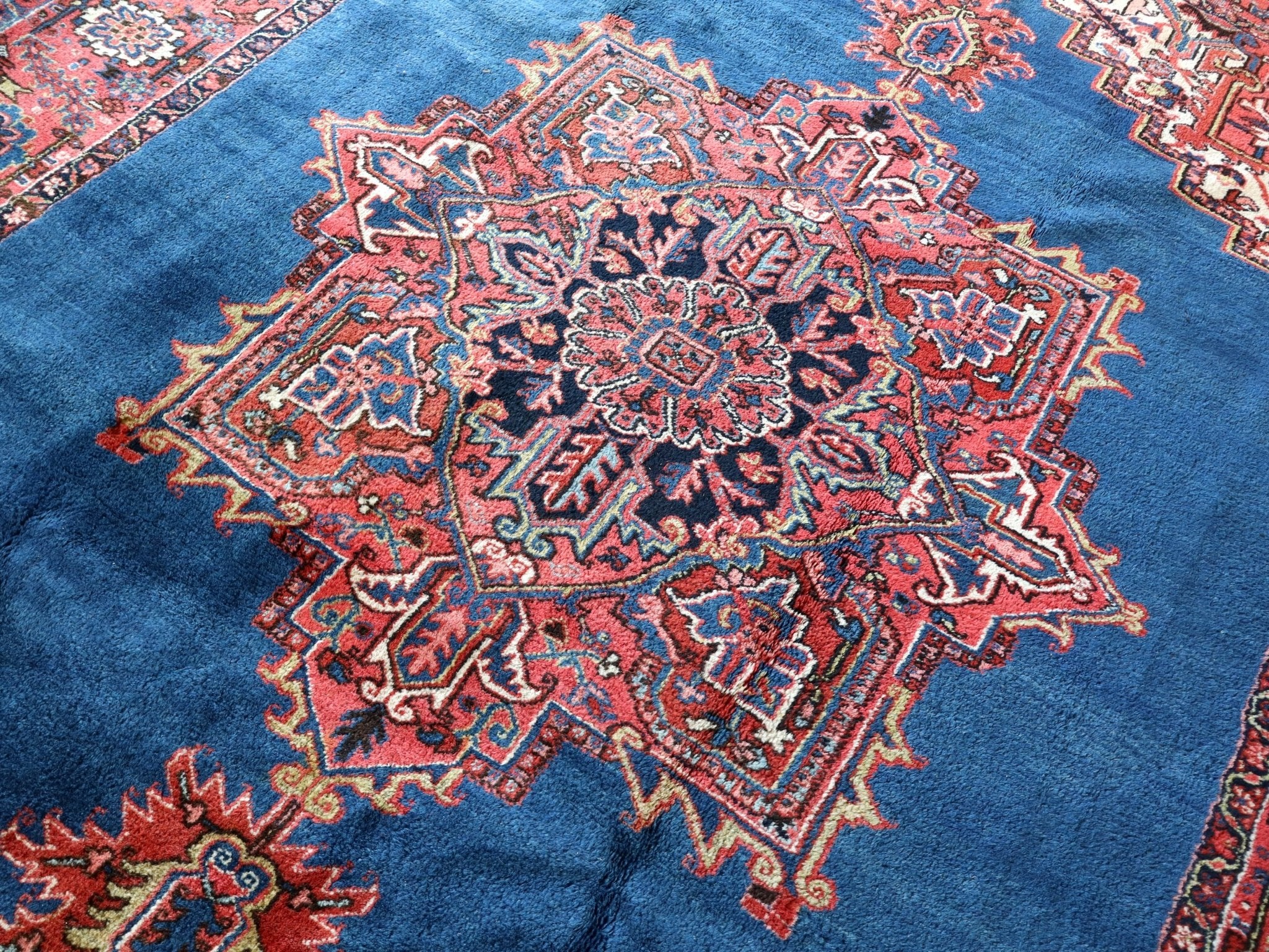 Persian Heriz rug center medallion on blue field with red ornamental surround