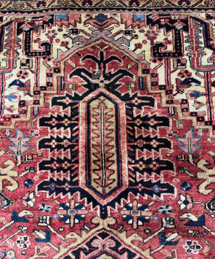 Persian Heriz rug medallion close-up with red, cream, and navy geometric ornament
