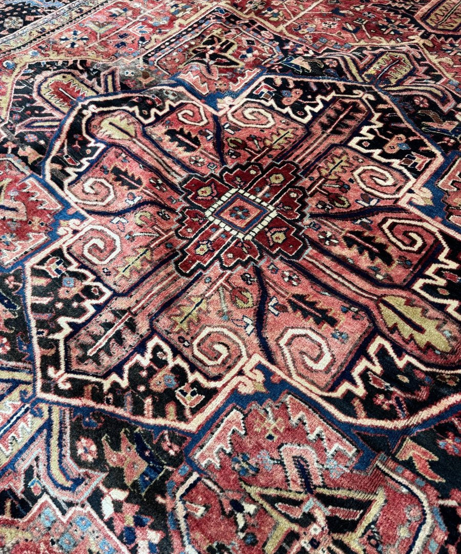 Persian Heriz rug close-up of swirling motifs in red, blue, and cream