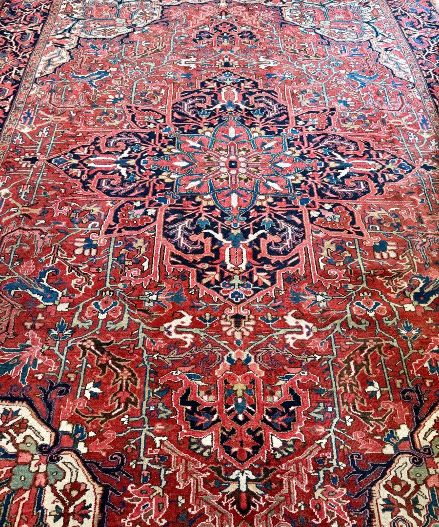 Persian rug with red ground and dense scrolling medallions in blue, teal, and cream.