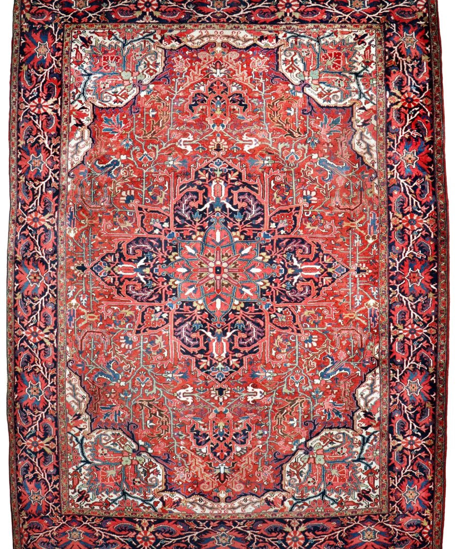 Rectangular red Persian-style rug with navy border and detailed floral medallion layout