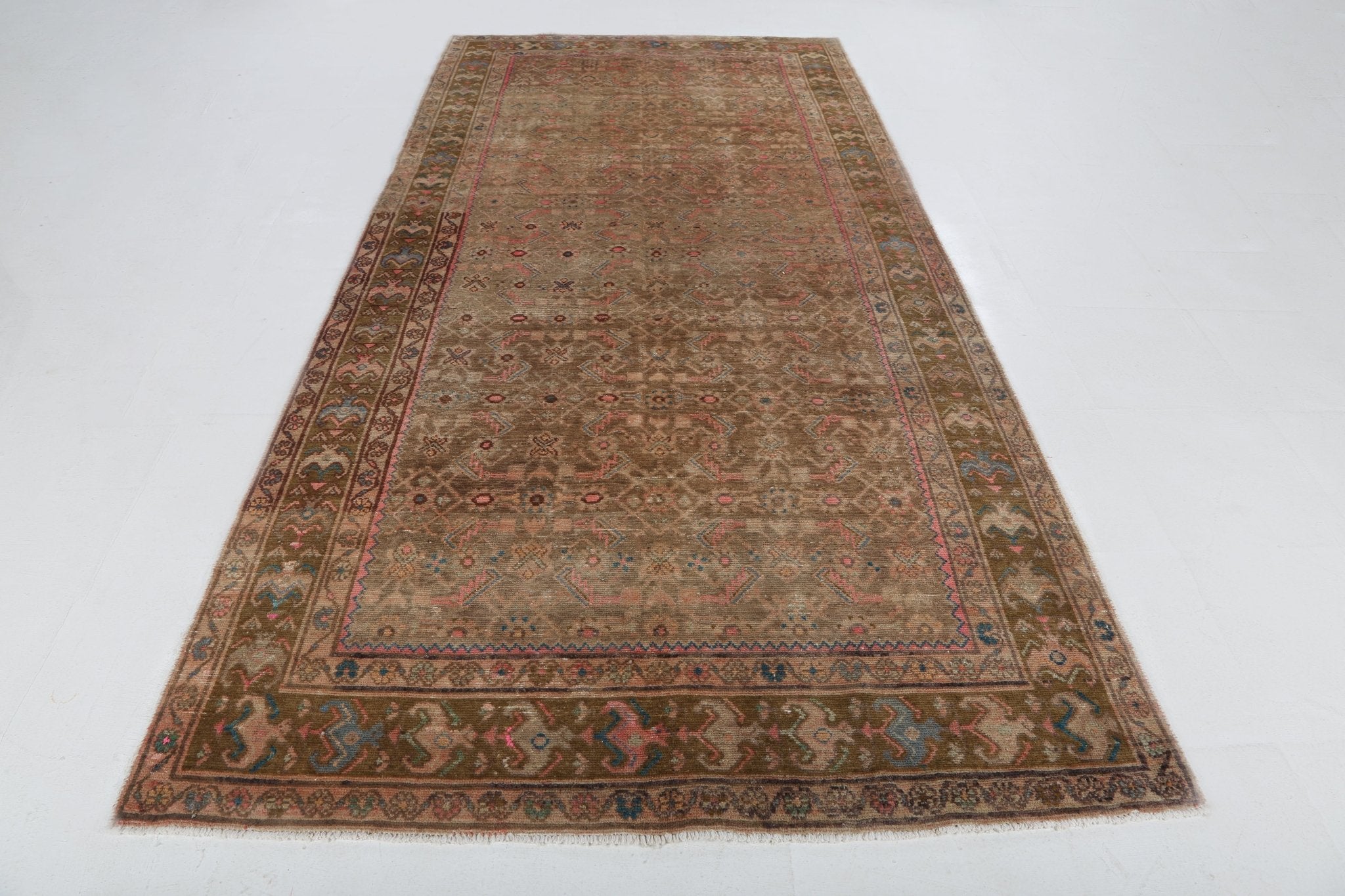 Rust-toned Persian rug with central medallion pattern and blue-red border, full view.