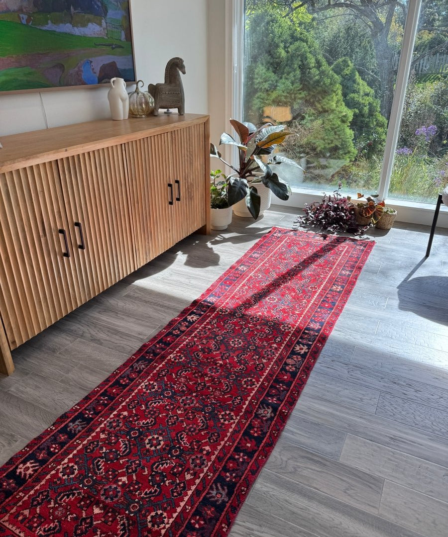 Persian-style runner rug, red ground with dark blue and beige repeating geometric pattern