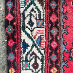 Persian runner rug, red floral and geometric border detail with cream accents
