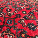 Persian runner rug, red field with black and teal medallion motifs