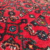 Persian runner rug, red field with black and teal medallion motifs