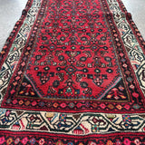 Red runner rug center panel with intricate geometric medallions and border stripe.