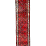 Red Persian-style runner rug with medallion motif and cream geometric border.