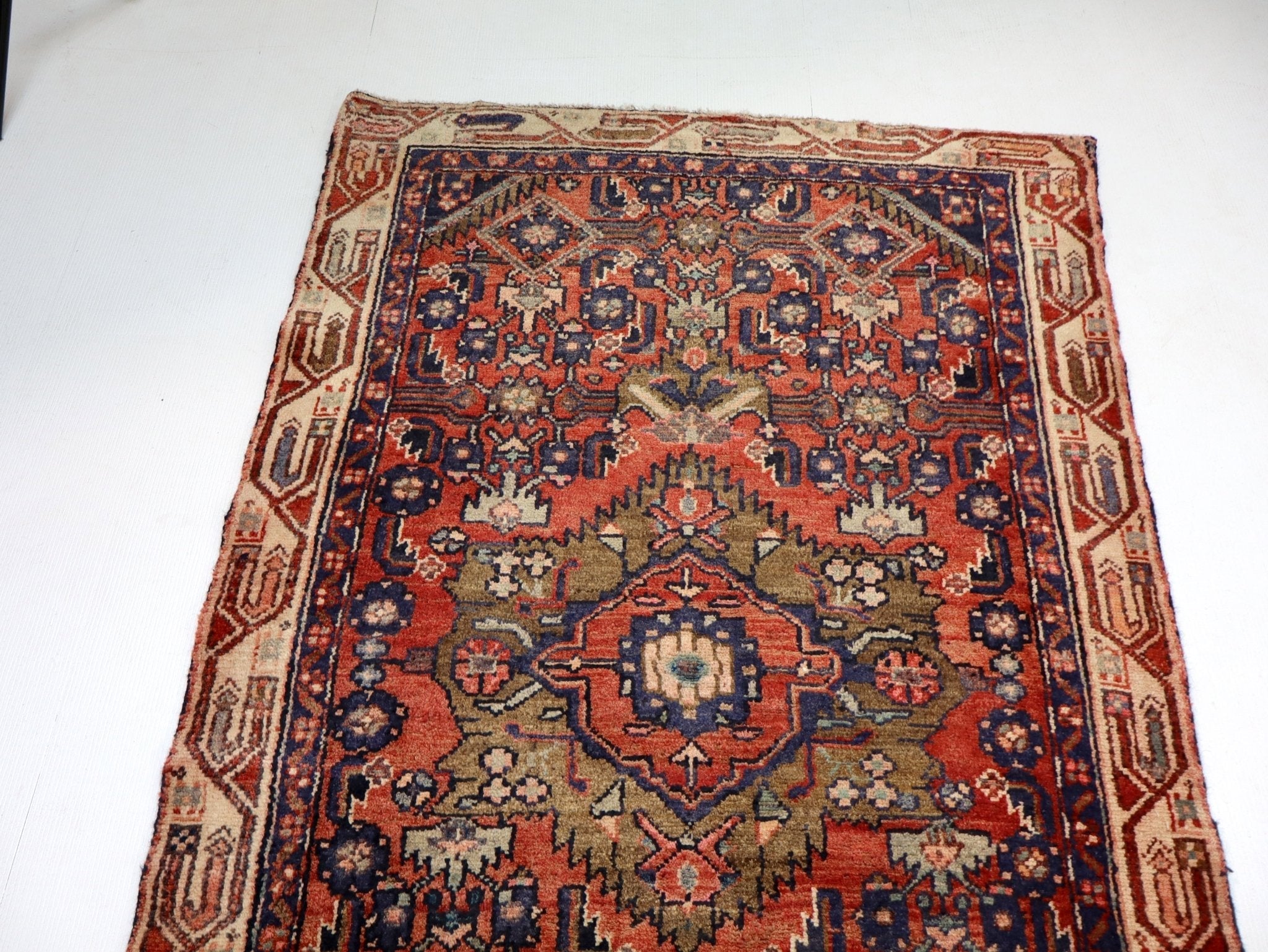 Persian runner rug with red, navy, and beige geometric medallion pattern