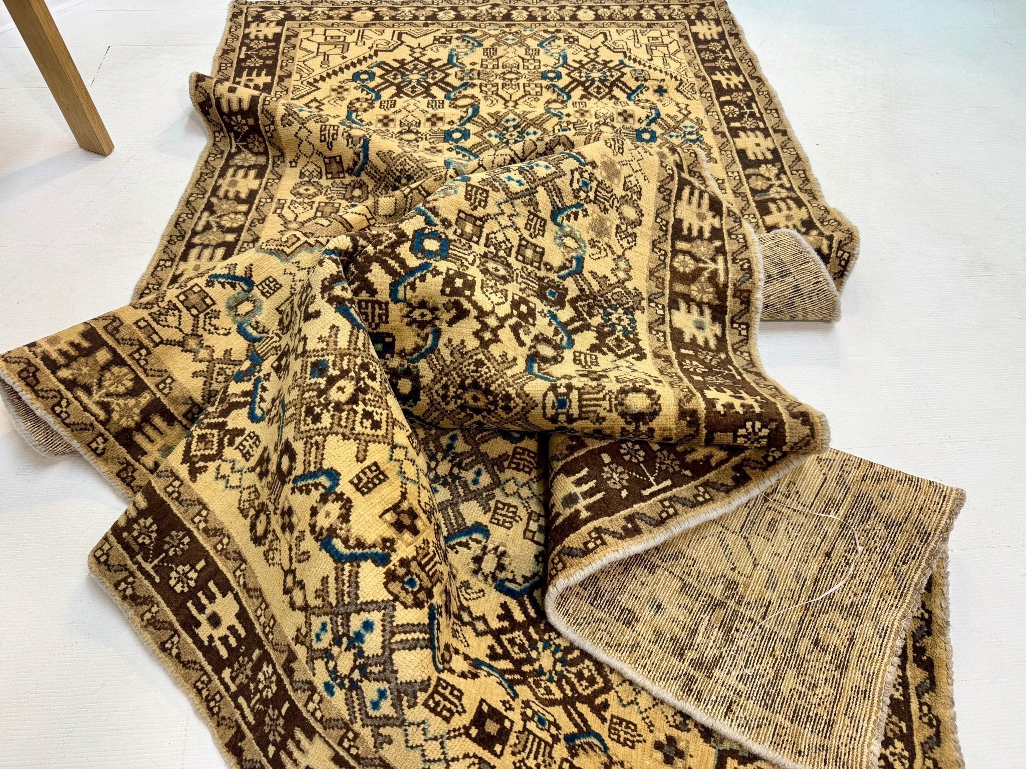 Persian runner rug with beige field, blue motifs, and dark brown border