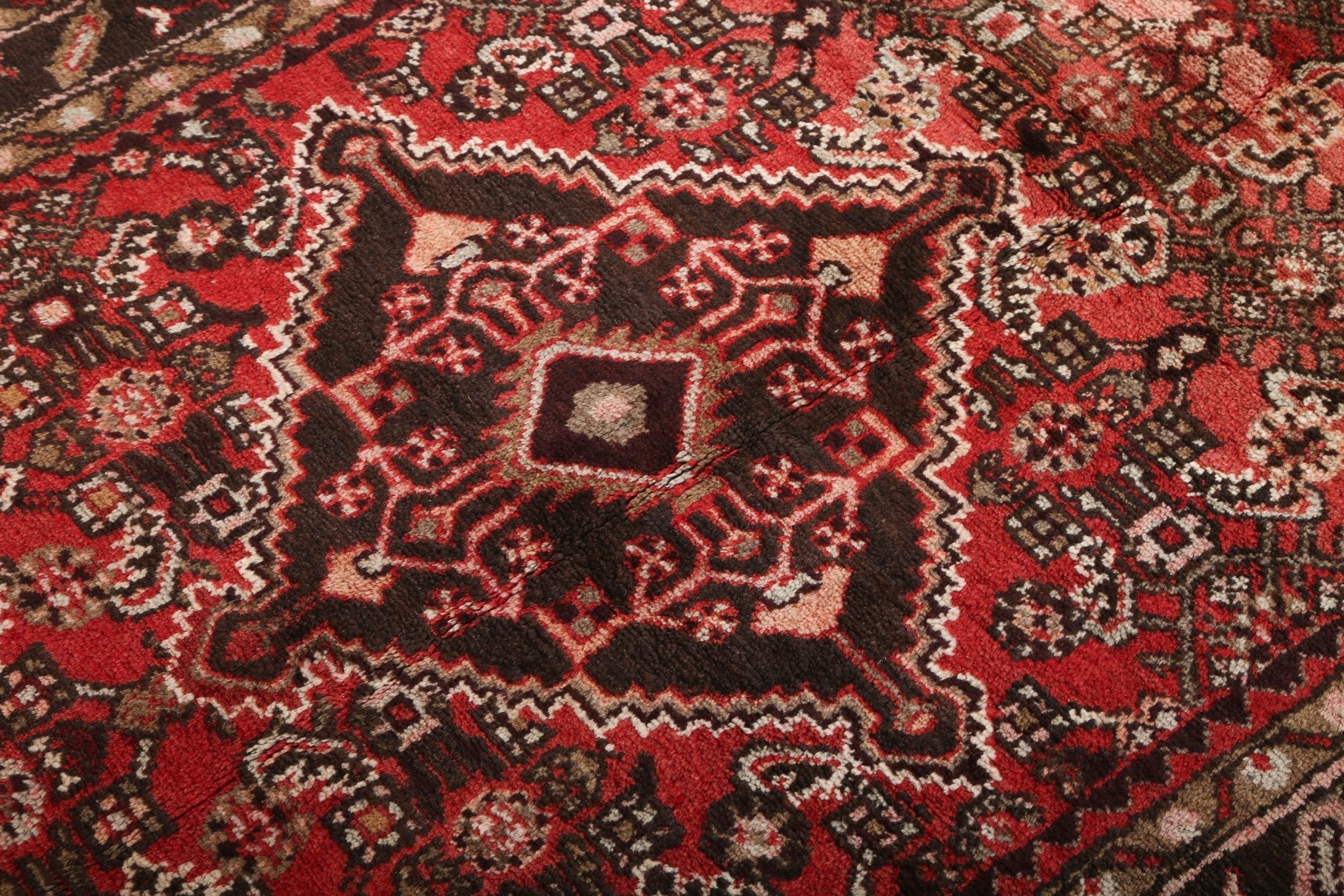 Runner rug central medallion close-up in red, black, and cream