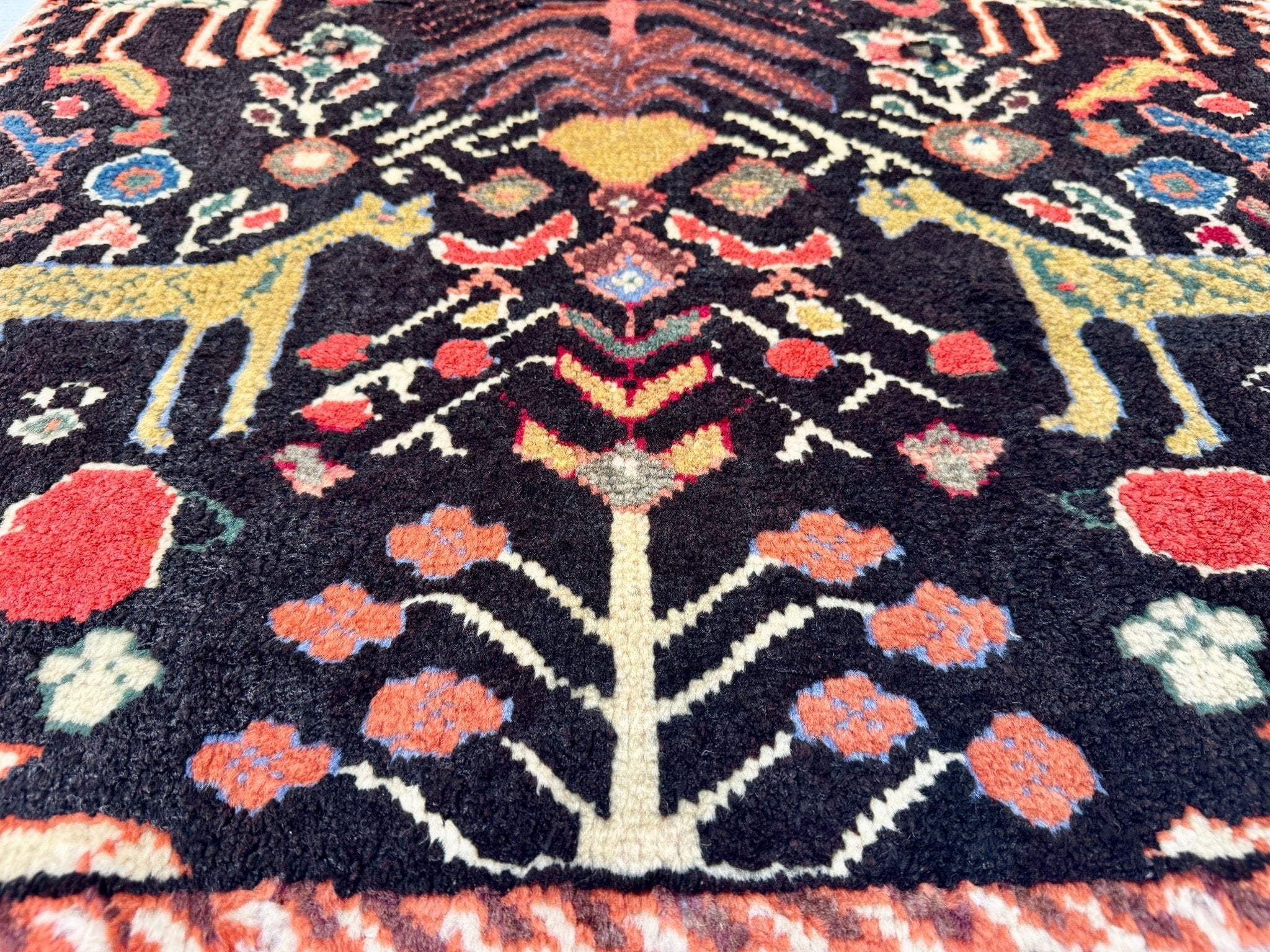 Persian Ilam-style rug central rosette with dark navy ground and bright orange, red, and cream dots