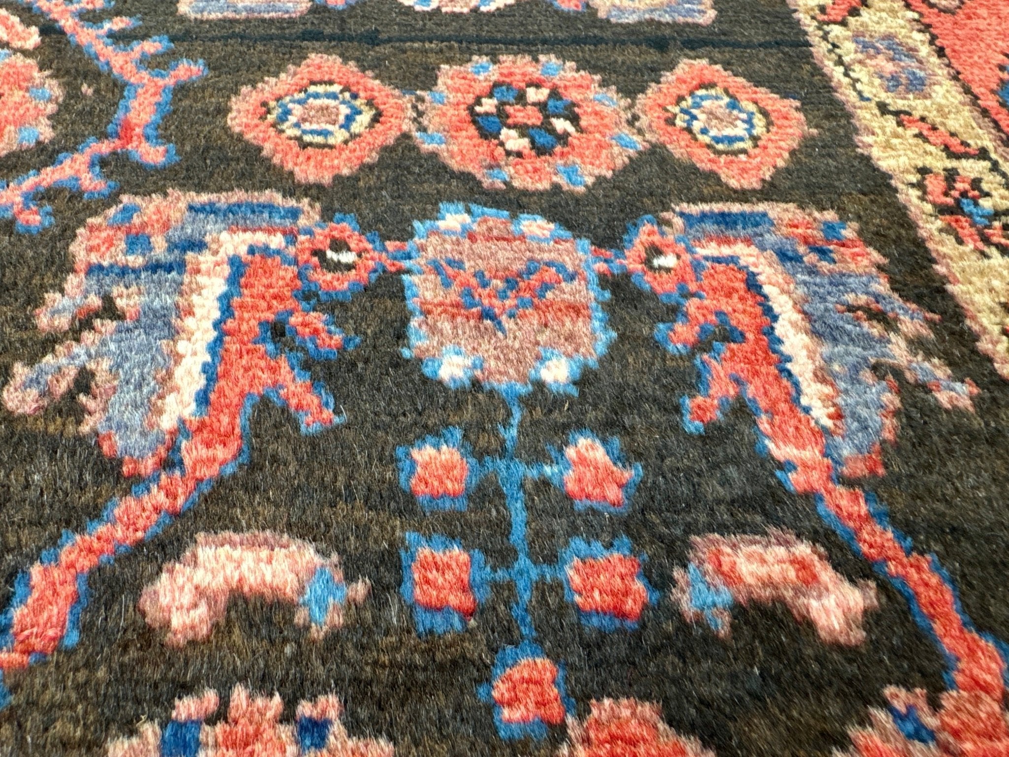 Dark navy Persian-style rug with blue and orange medallions and ornamental vines