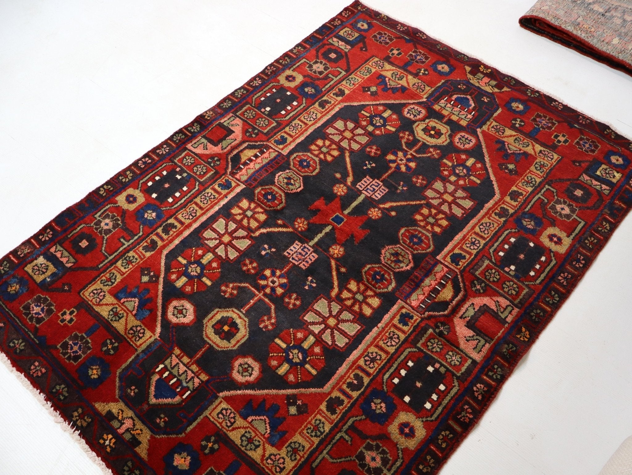 Persian Hamadan rug top view, red and navy with multicolor center medallion; fringed