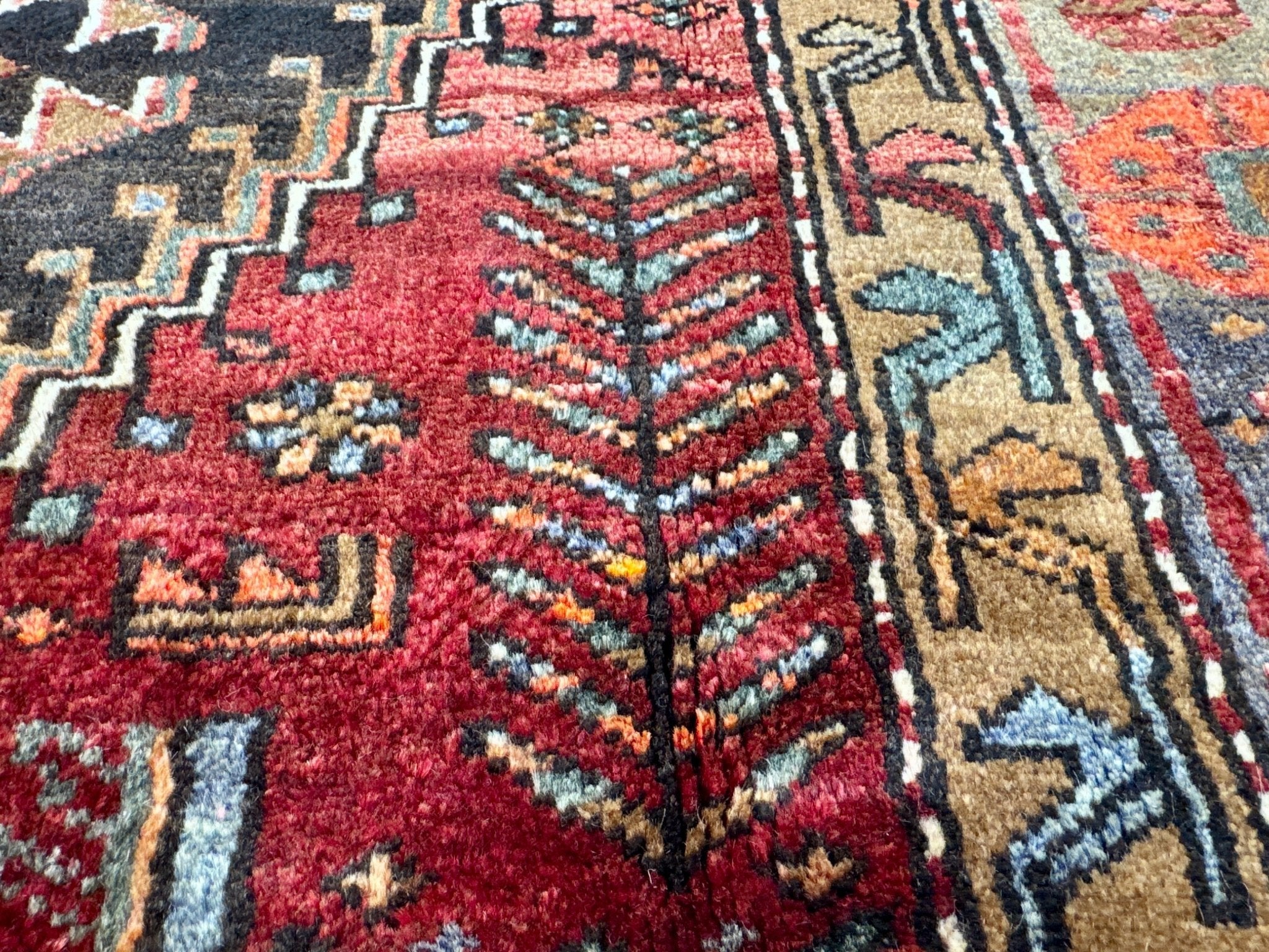Persian Zanjan rug close-up of dense patterning in red, navy, cream and teal accents