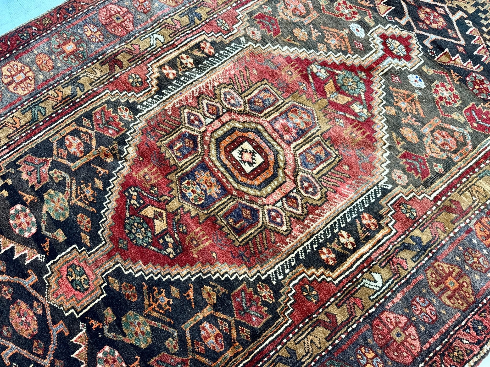 Persian Zanjan rug close-up of central medallion with red, navy, cream and diamond accents