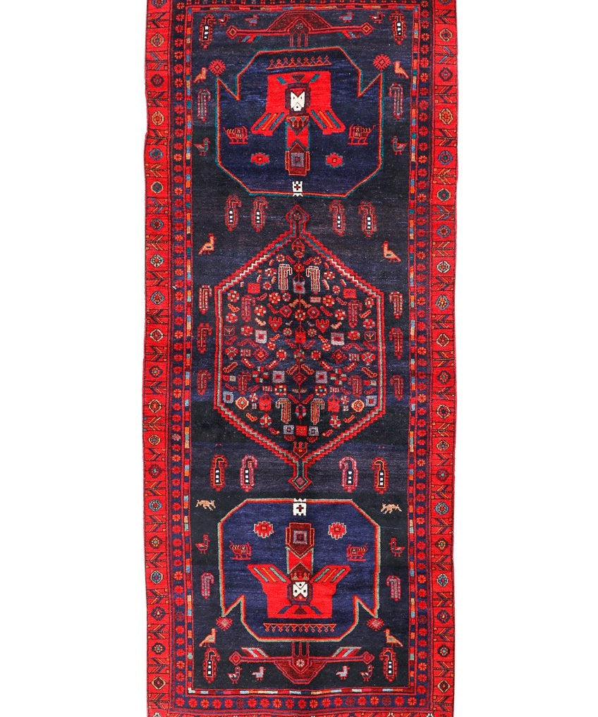 Kurdish Koliai rug, dark navy field with red border and central geometric medallion.
