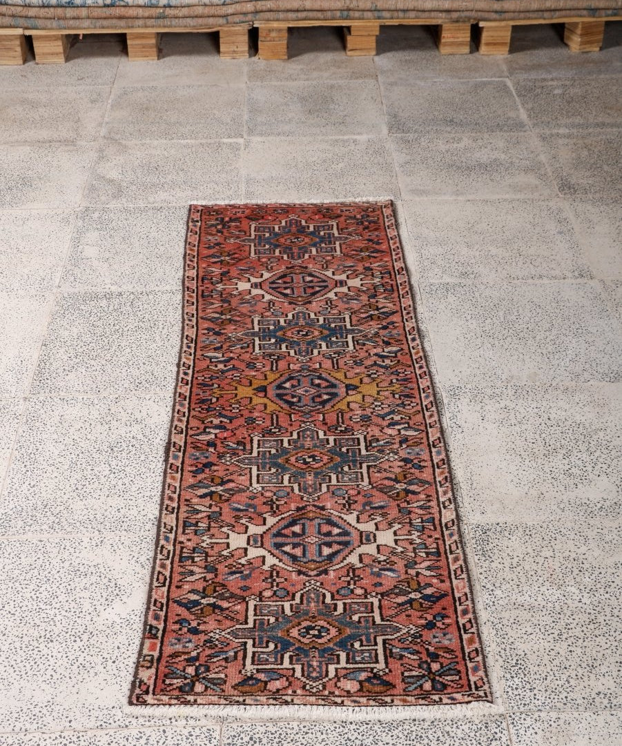 Persian-style runner rug with rust-red tones and navy-blue geometric pattern