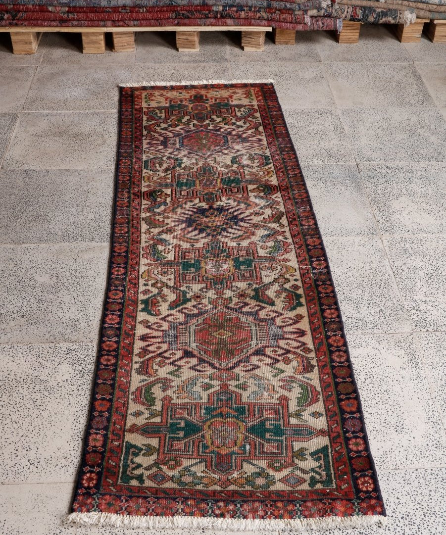 Persian runner rug with cream field, red border, teal and multicolor geometric ornamentation