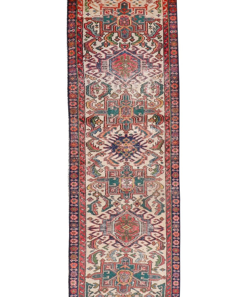 Persian-style runner rug with red border, cream field, and geometric medallion motifs