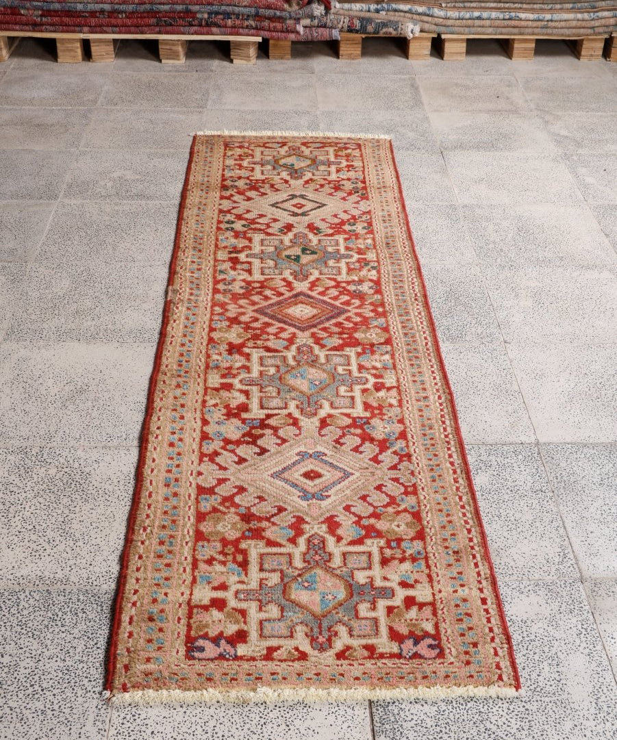 Red Persian-style runner rug with cream border and multicolor geometric pattern