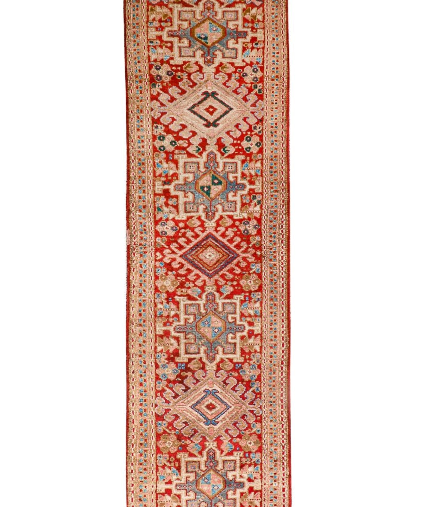 Persian-style runner rug with red field and geometric cream medallion motifs