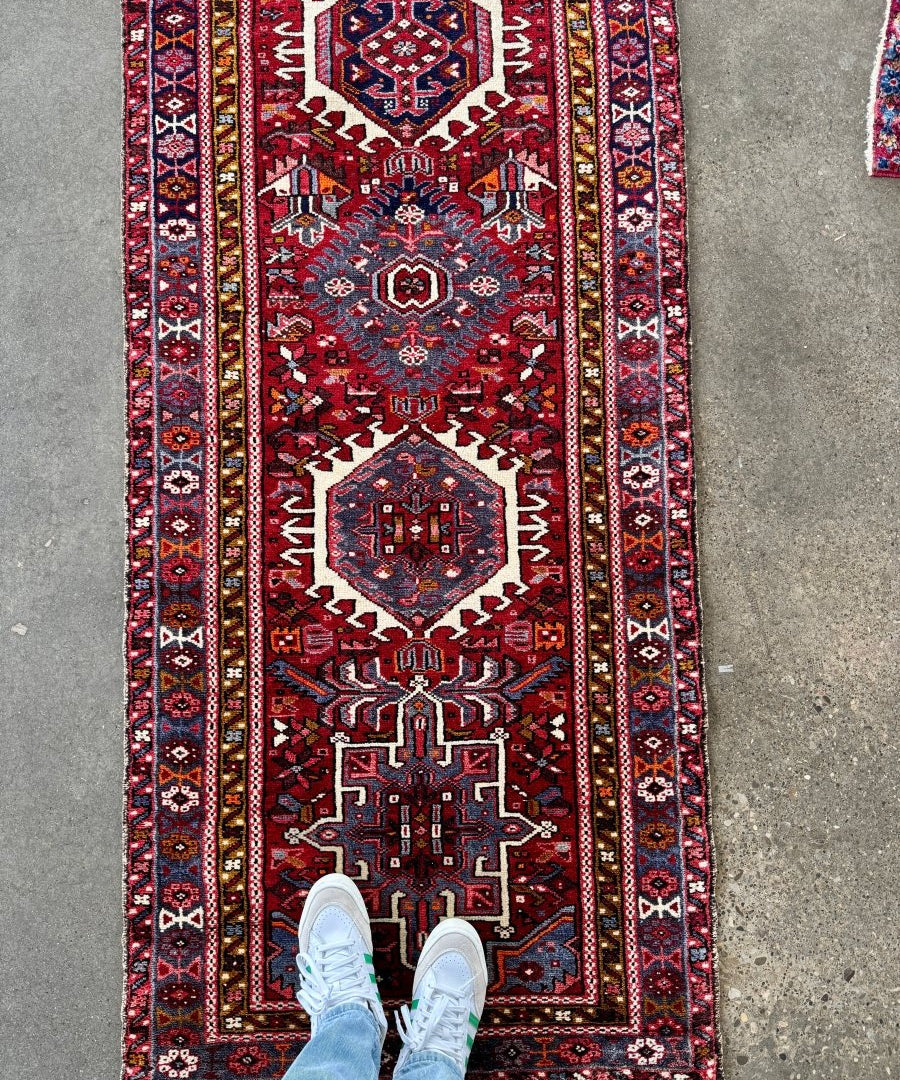 Full Persian-inspired runner rug with burgundy center medallion and navy cream border.