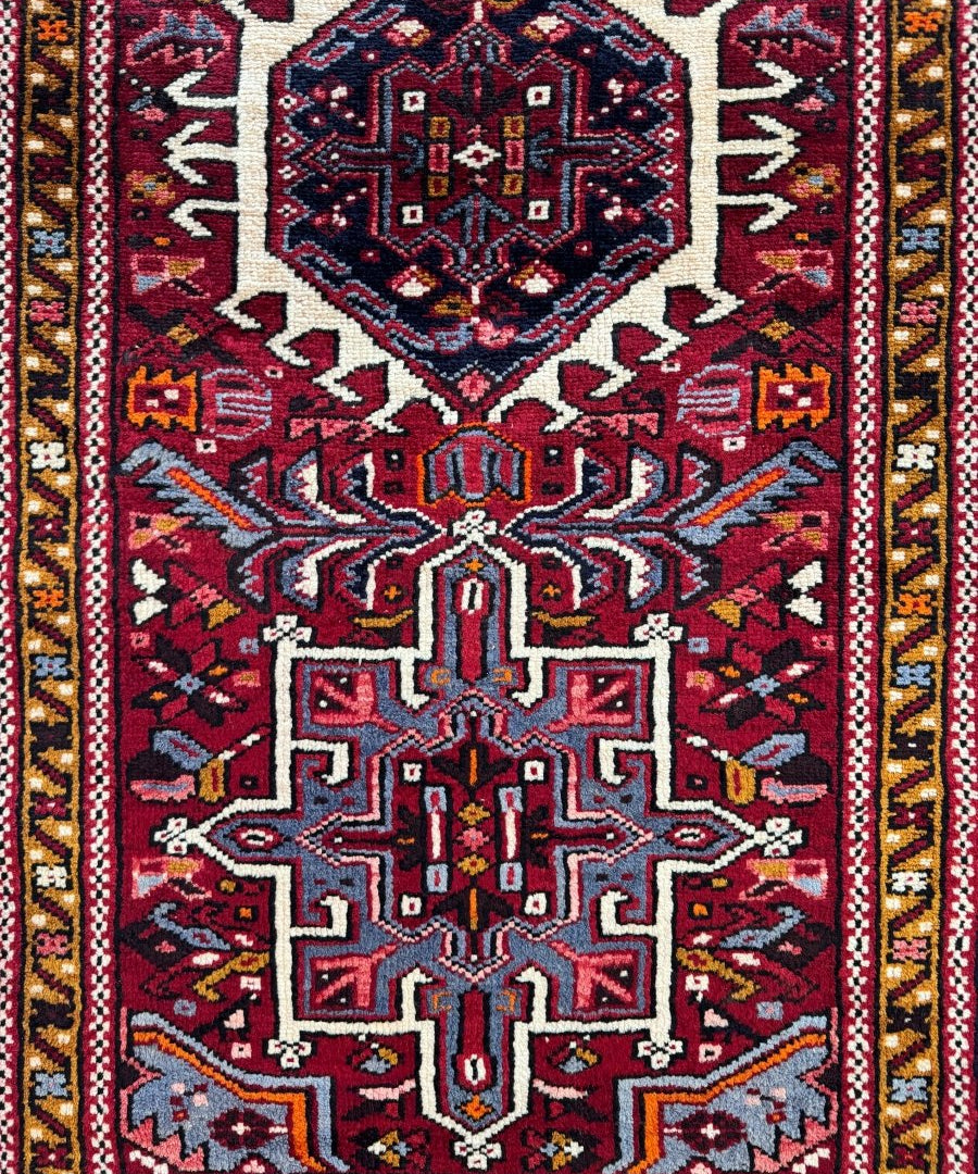 Persian-inspired runner rug with navy, burgundy, and cream geometric medallion pattern.