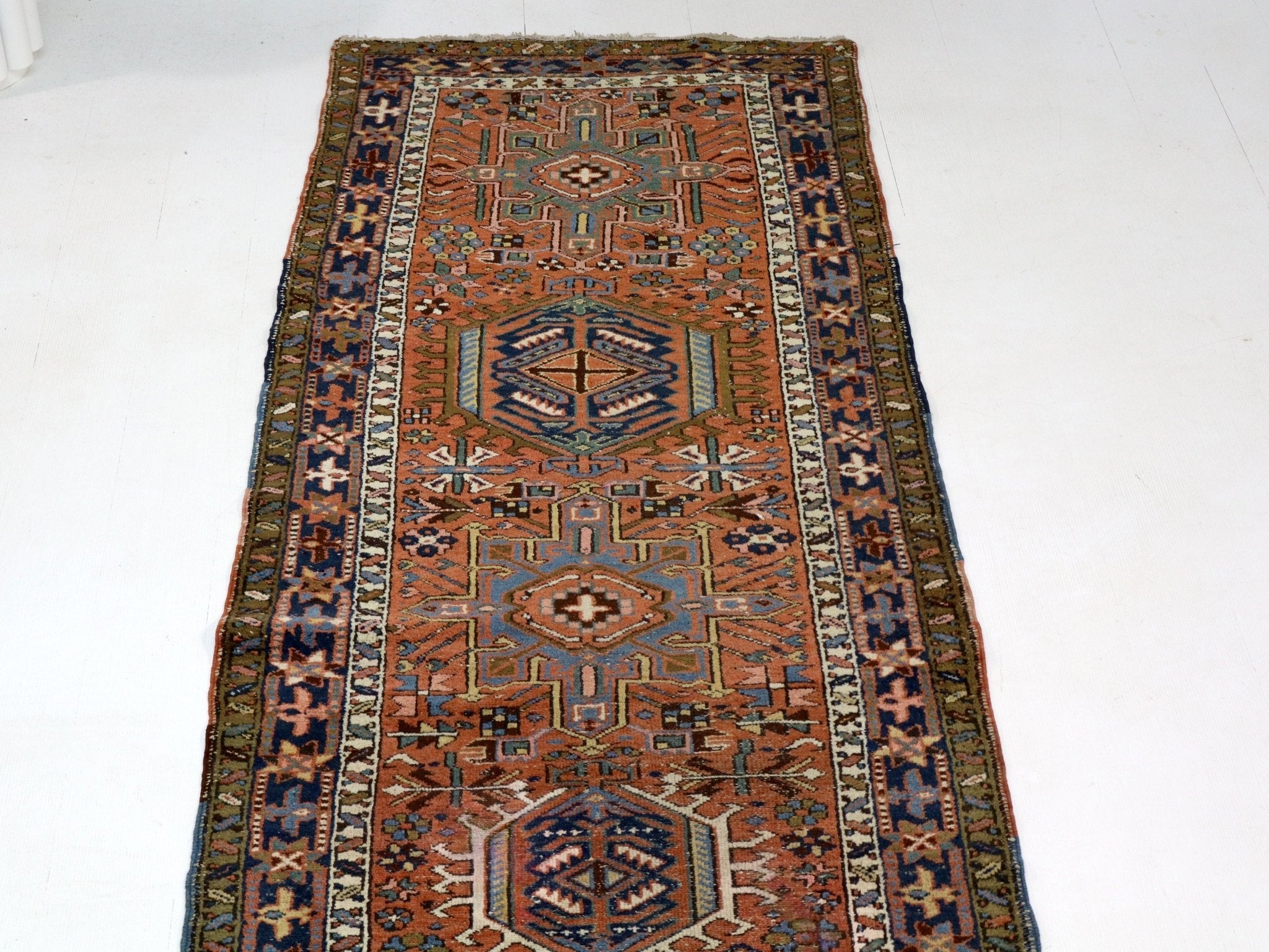 Close view of runner rug center with rust background and navy geometric details.