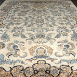 Persian Kashan rug with ivory field and blue floral medallion; ornate scrolling border