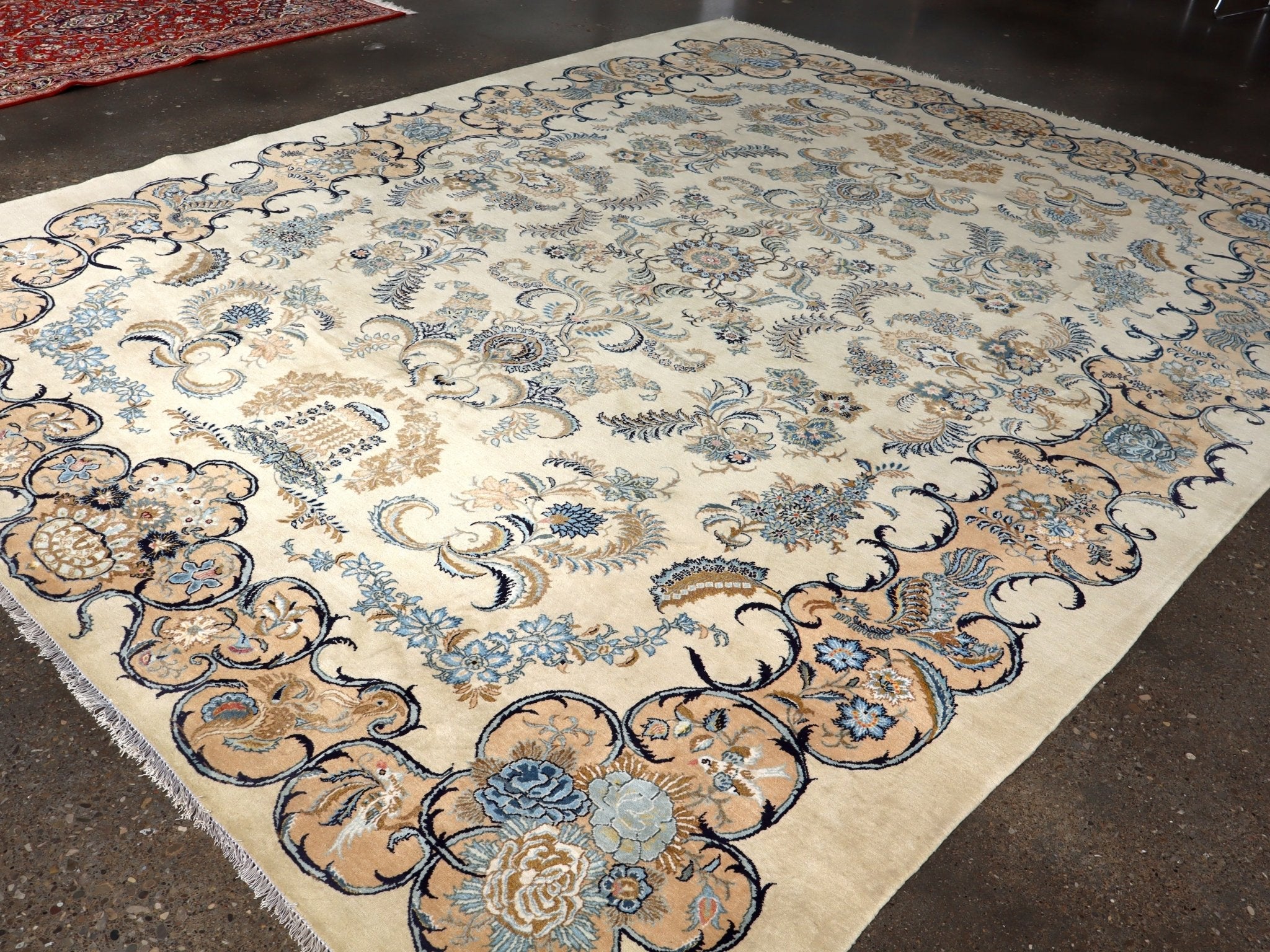 Persian Kashan rug laid flat with cream background, blue and tan floral corner motifs