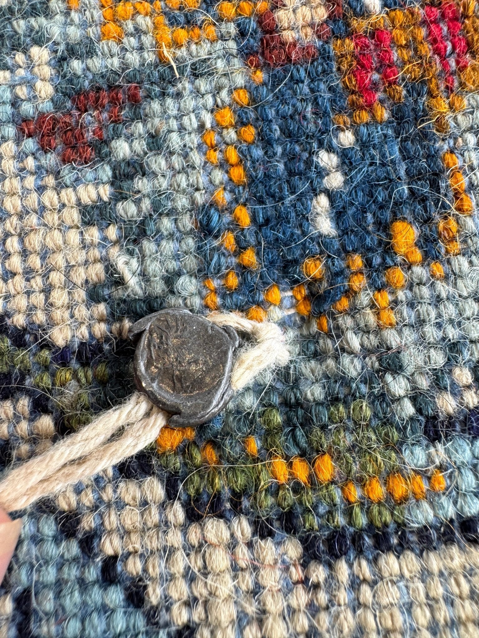 Persian Kashan rug texture detail with blue yarn loops, orange accents, and light fringe