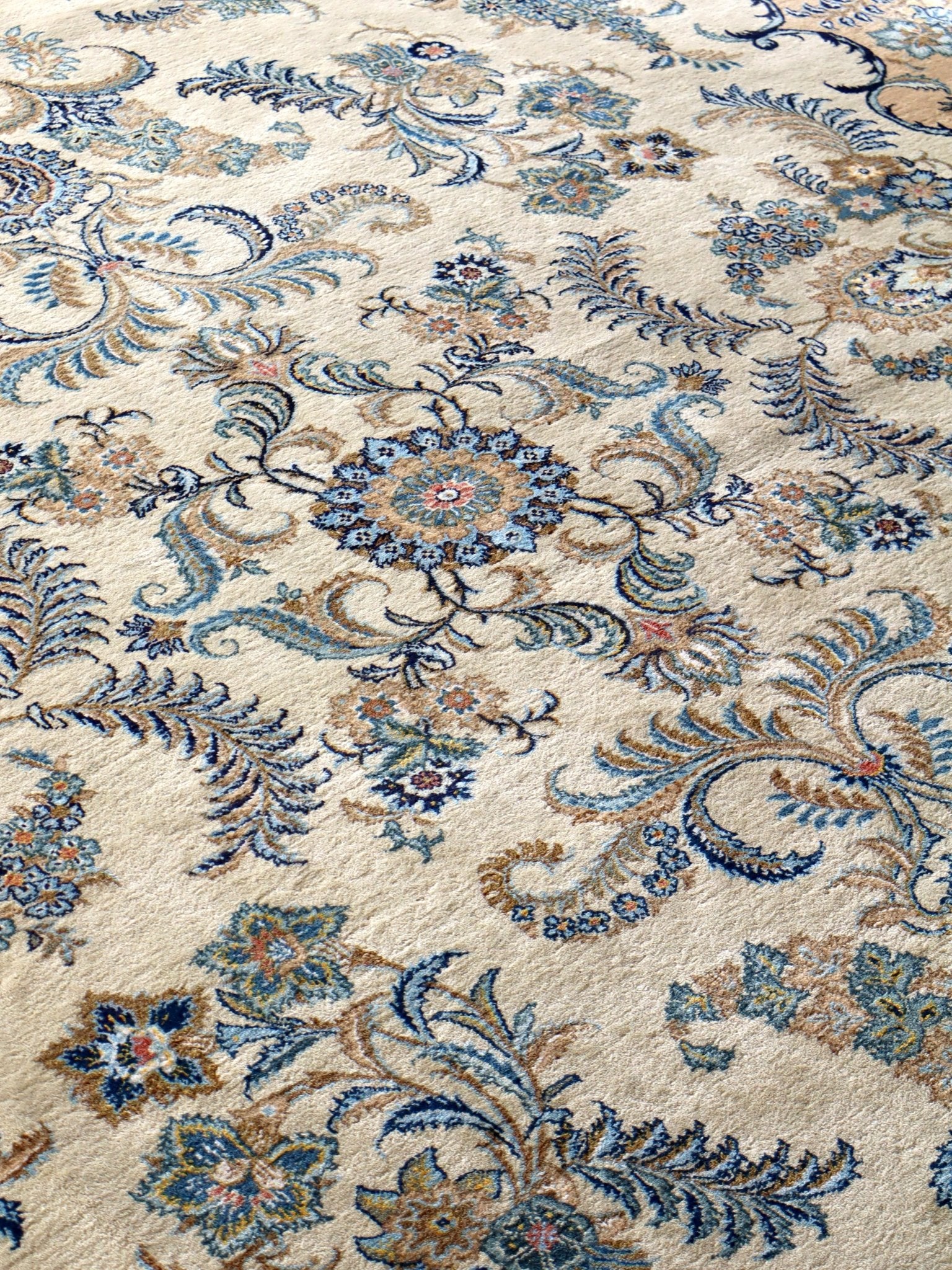 Persian Kashan rug wide view of ornate scrolling vines and floral bursts in blue