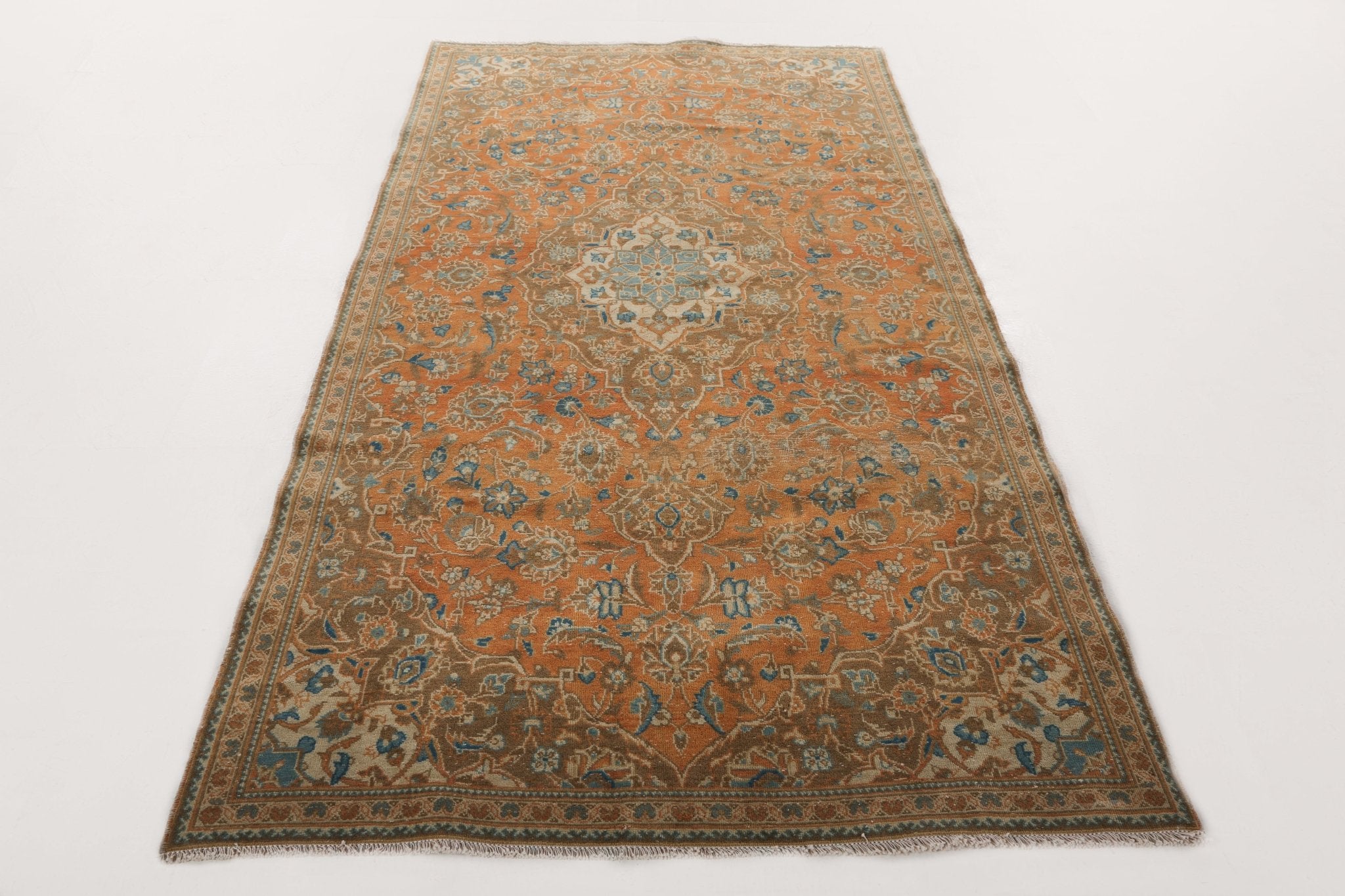 Kashan-style rug with orange field, blue decorative details, and framed border