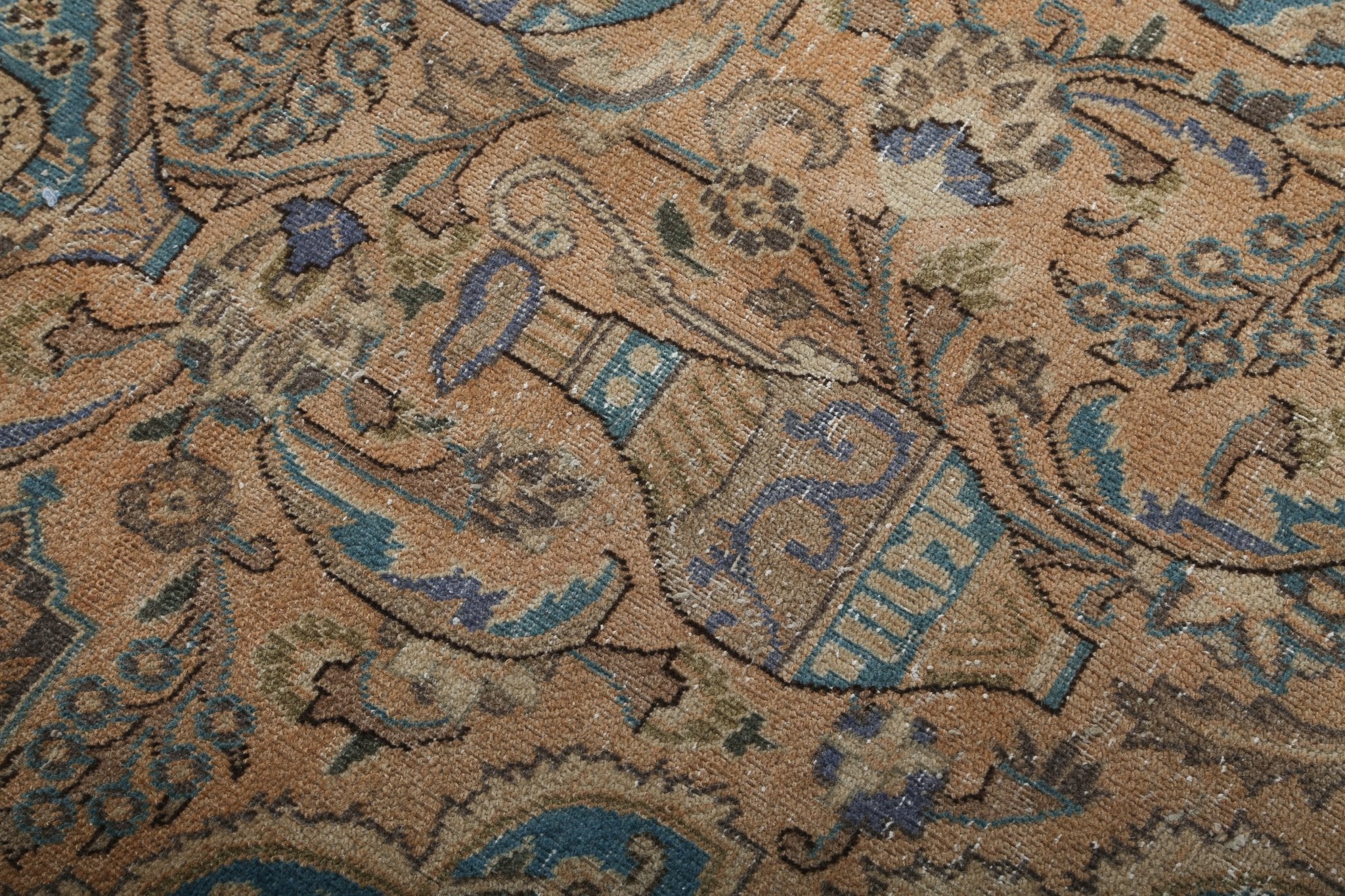 Persian rug close-up of allover pattern in tan and blue with dark accents