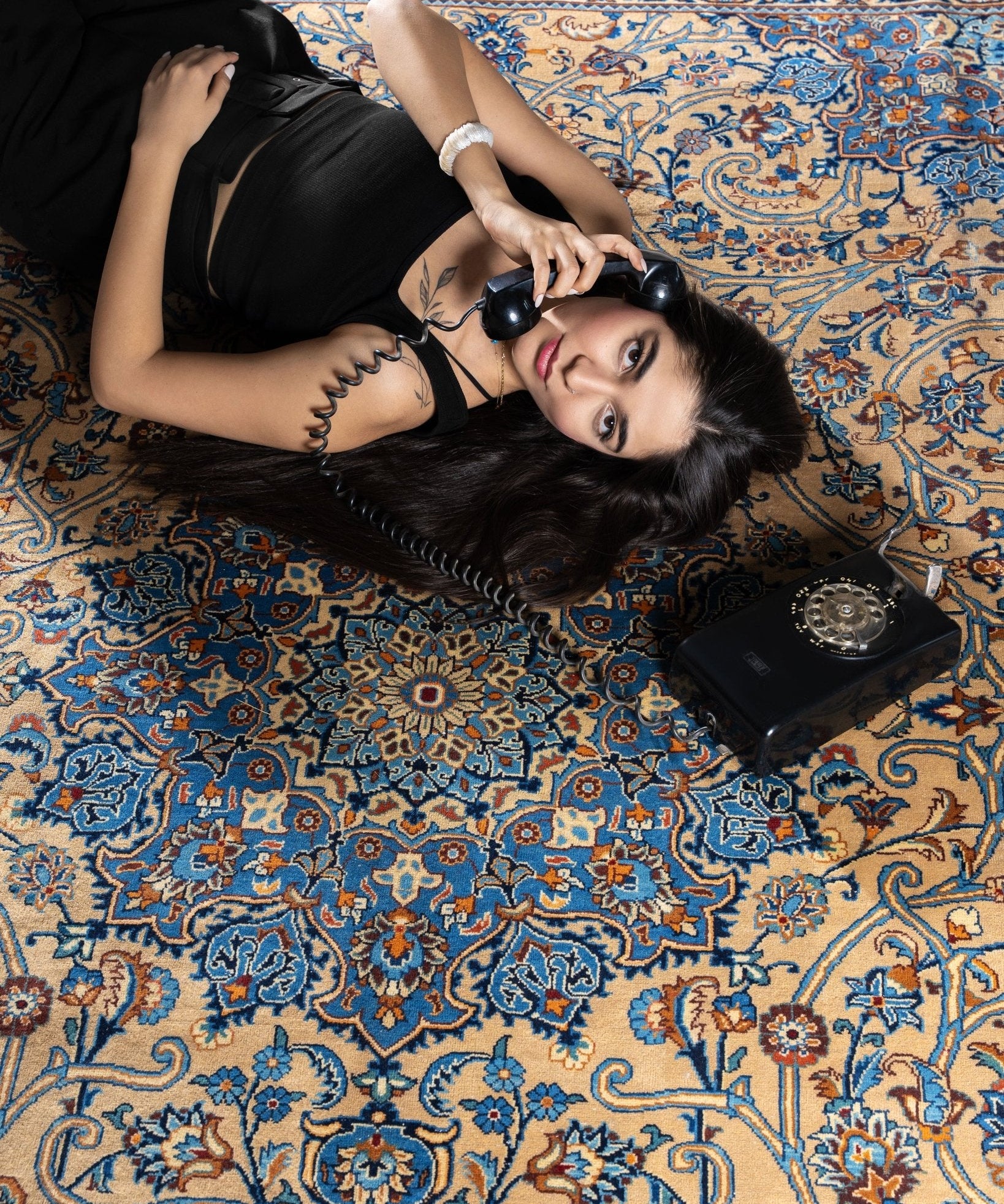 Blue and beige Persian-style rug with orange floral vines and central medallion design
