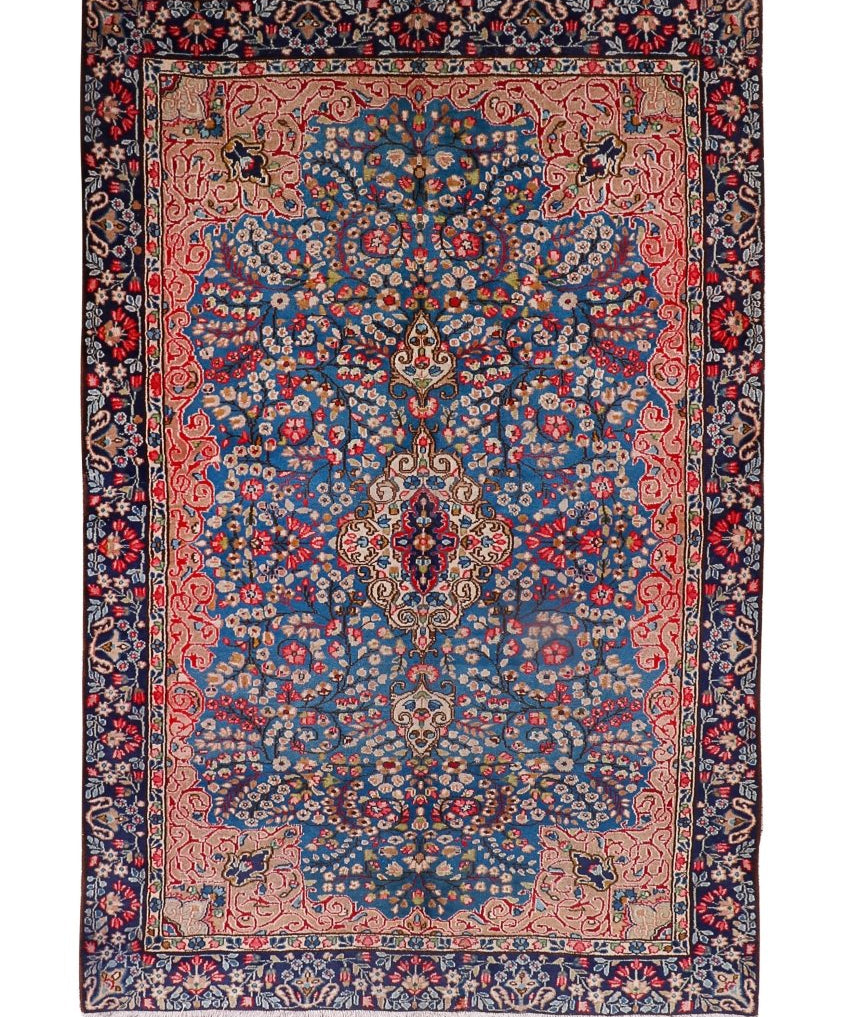 Persian-style area rug with navy, red, and blue floral medallion pattern and border