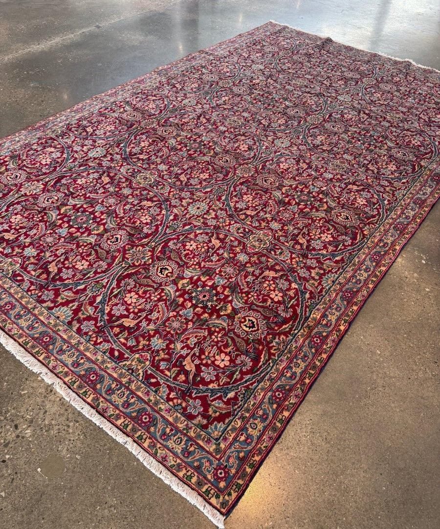 Persian Kerman rug with red floral scrolling pattern and navy border trim