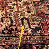 Persian Heriz-style rug close-up showing a cross-like motif on the patterned field