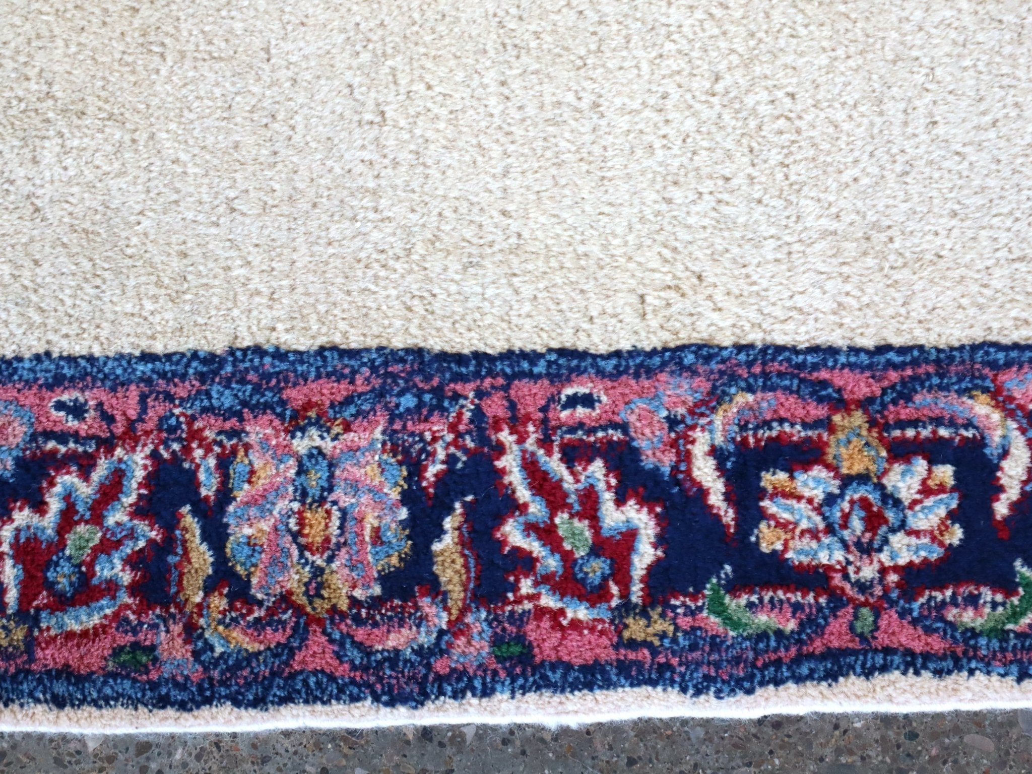 Rug border strip in navy with red and multicolor floral accents on off-white