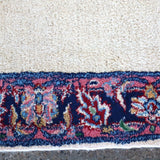 Rug border strip in navy with red and multicolor floral accents on off-white