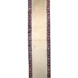 Cream runner rug end view with dark blue border and red ornamental pattern