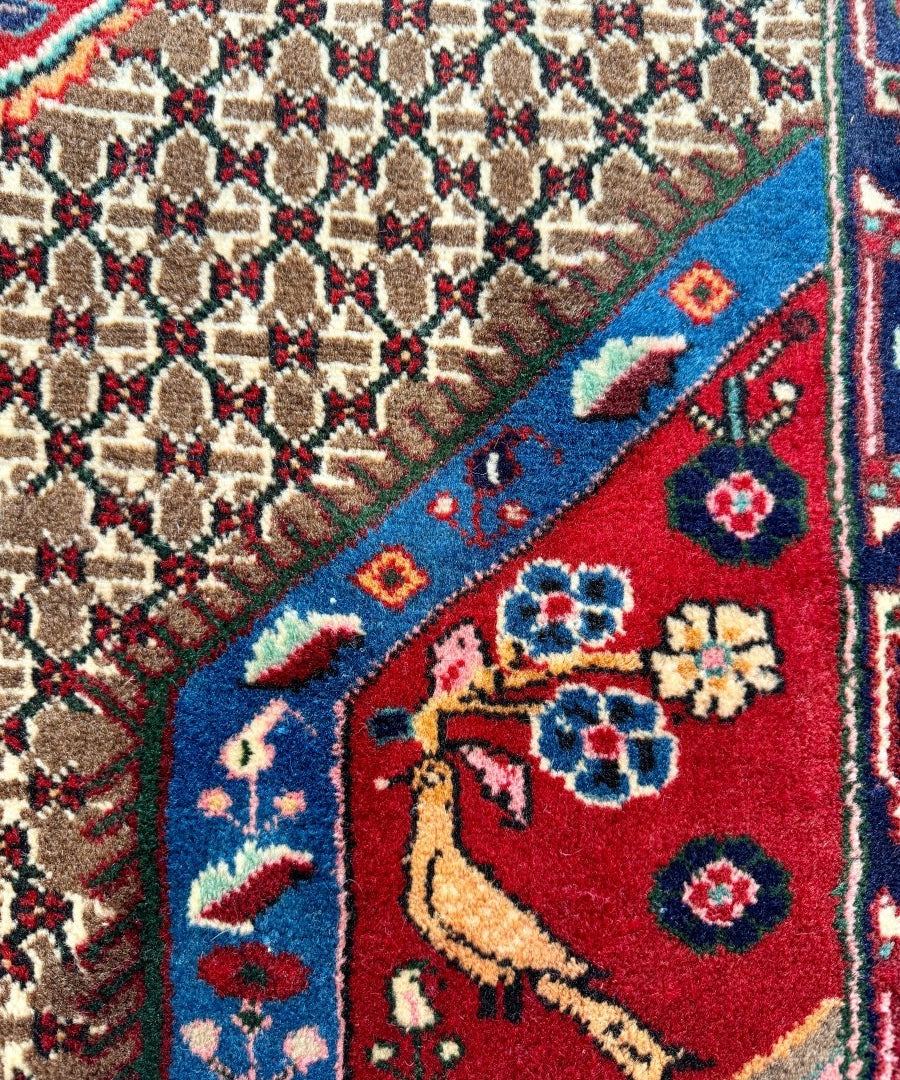 Koliai rug close-up of beige lattice pattern with red and blue decorative motifs.