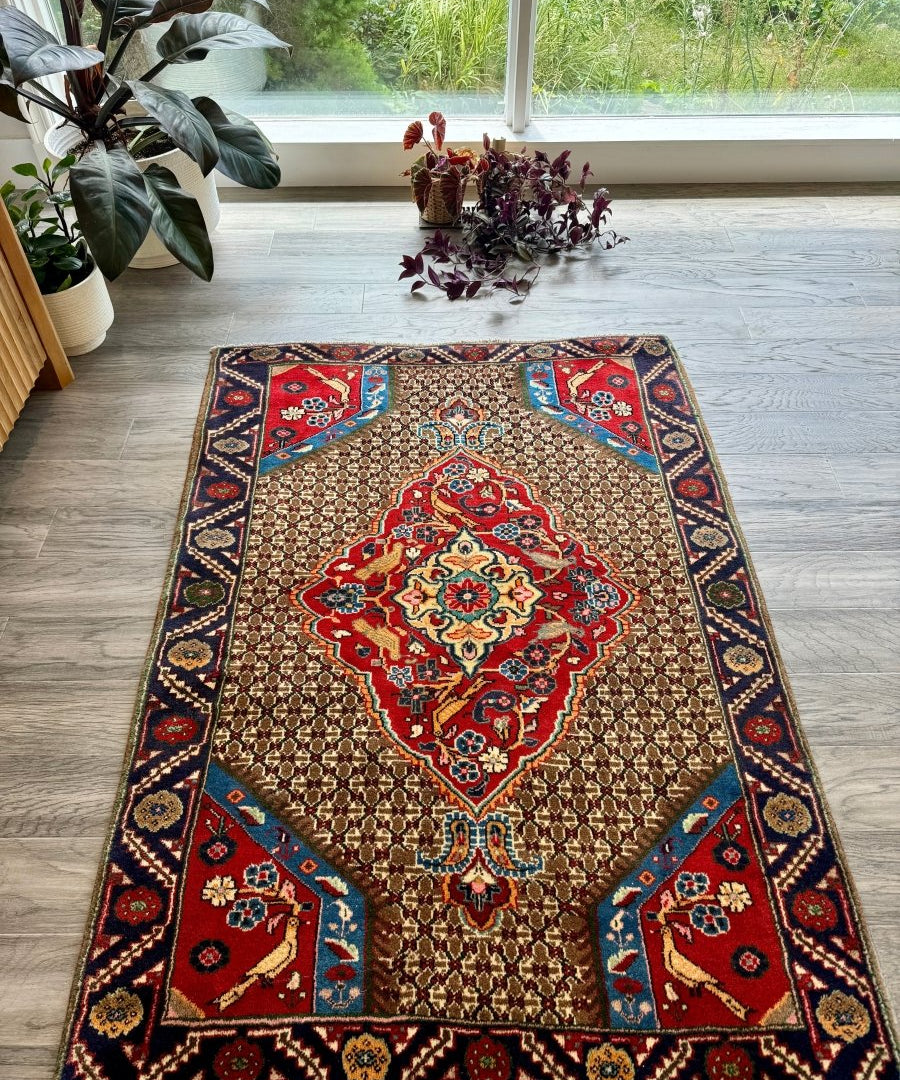 Koliai rug featuring central red medallion, beige ground, and blue corner panels.