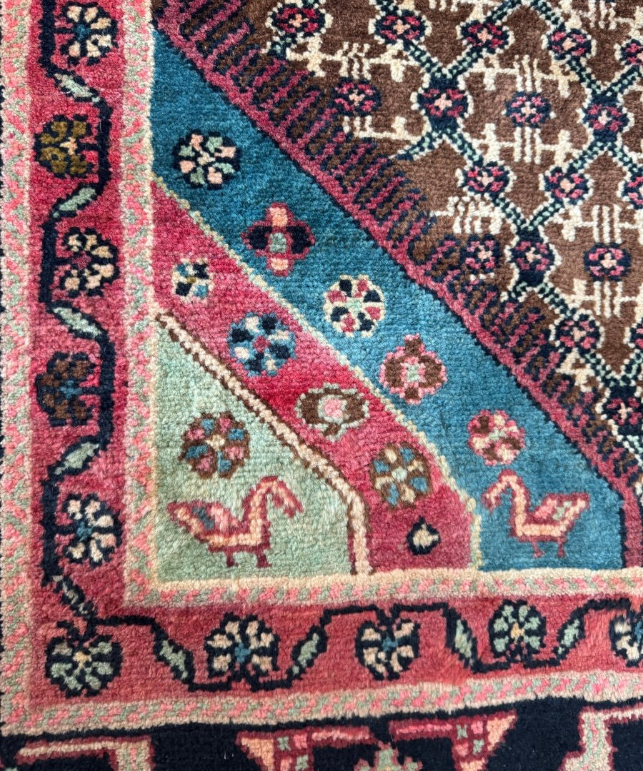 Persian Koliai rug corner detail with teal, pink, and beige geometric motifs