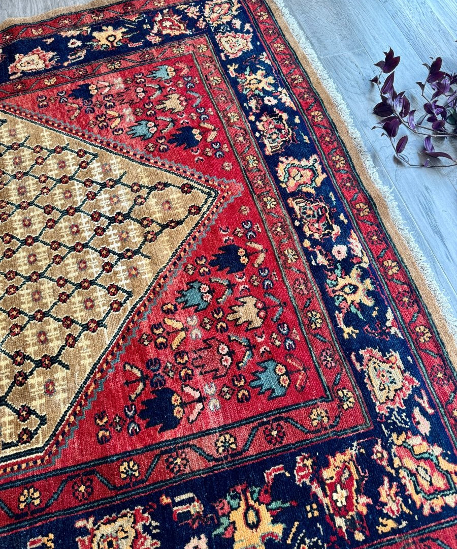 Persian Koliai rug corner view with red and navy florals on cream background
