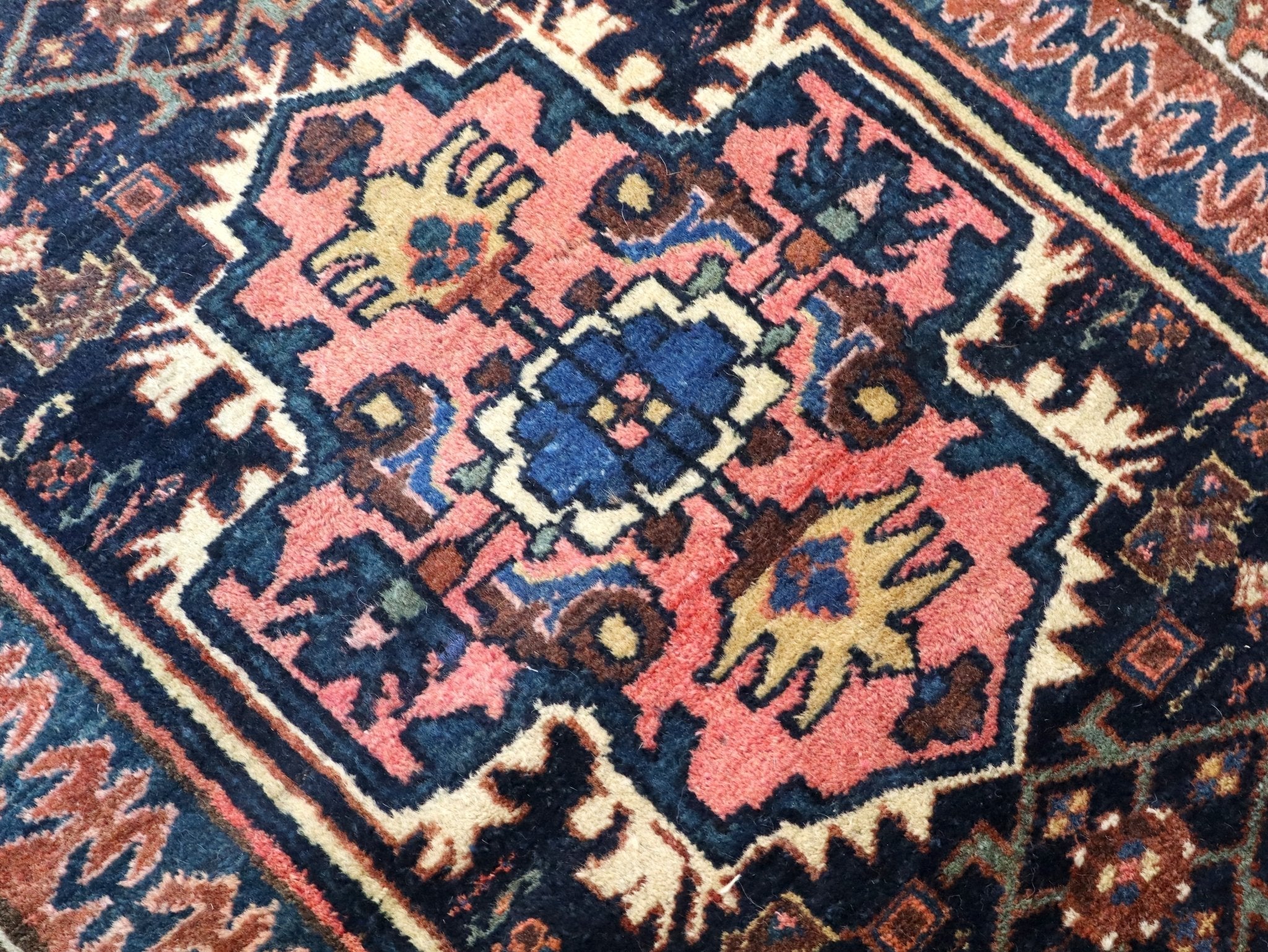 Persian Kurdi rug close-up with coral, pink, blue, and cream medallion motifs